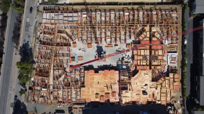An overhead image of a large wooden building as it's being constructed.